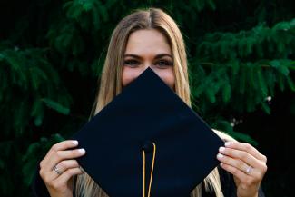 woman covering her face with blue paper by Evan Mach courtesy of Unsplash.